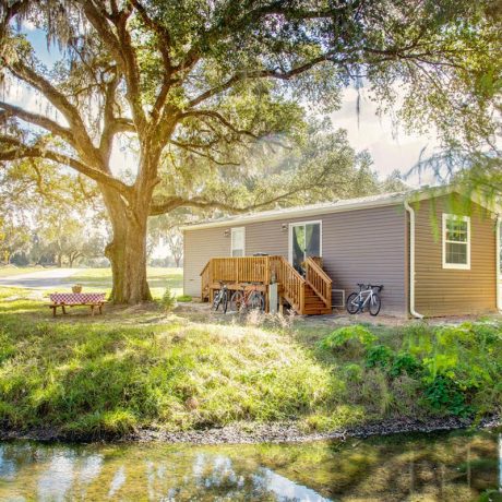 wide shot of building with bikes parked, trees, and grass