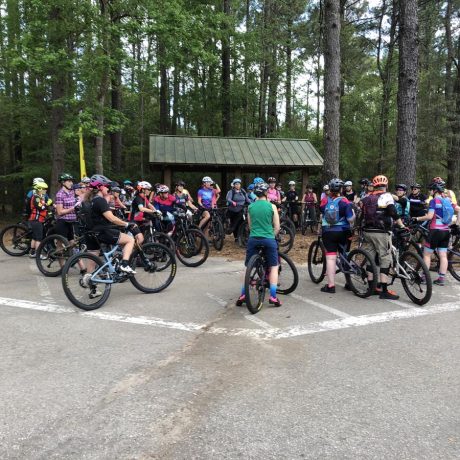 people gathering at trailhead on bikes