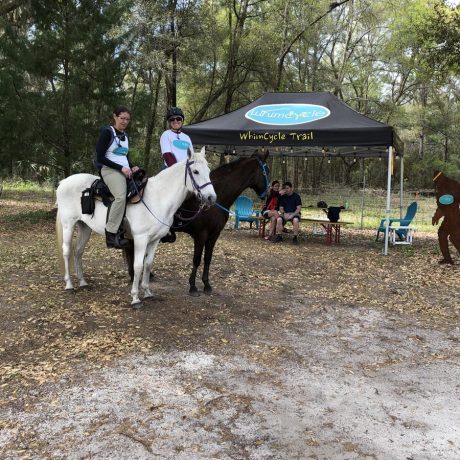 people smiling on horseback